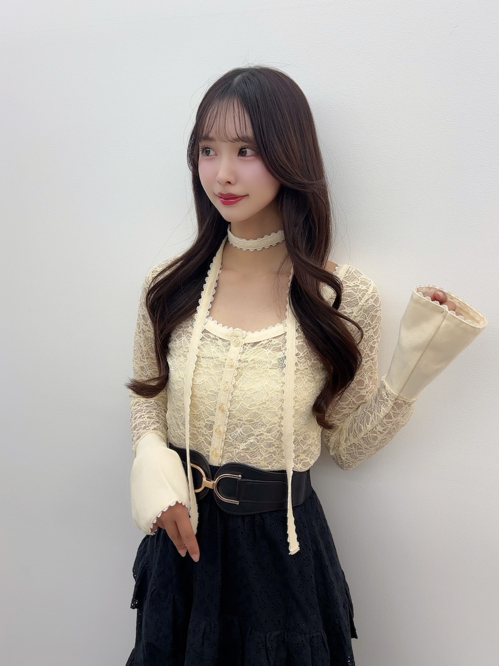 イエロー系のTシャツ/カットソー、ブラック系のスカート、ホワイト系のサンダルを着用したレディースの春コーディネートの6枚目の写真