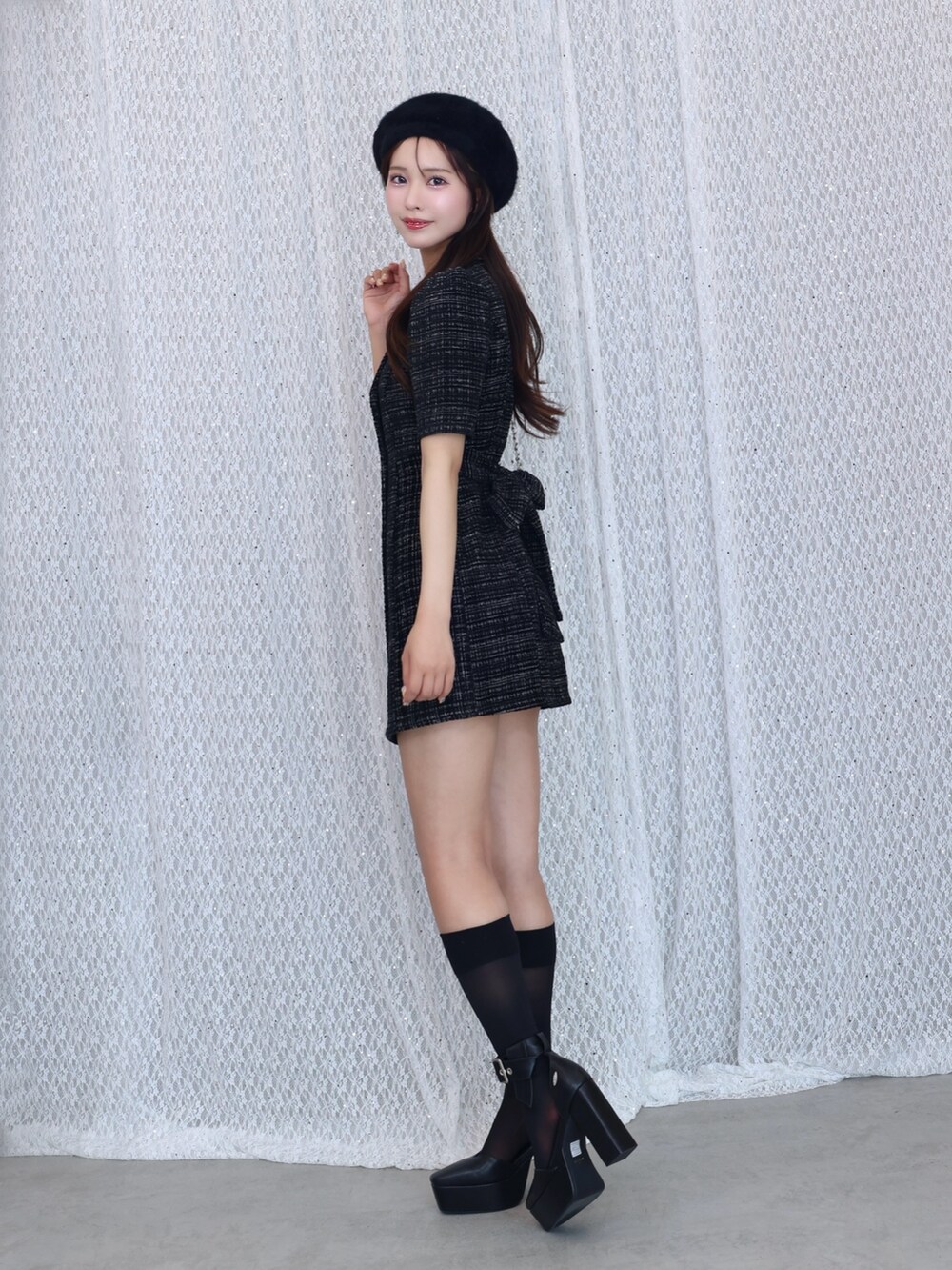 ホワイト系のハンドバッグ、ブラック系のワンピース、ブラック系のパンプスを着用したレディースの夏コーディネートの2枚目の写真