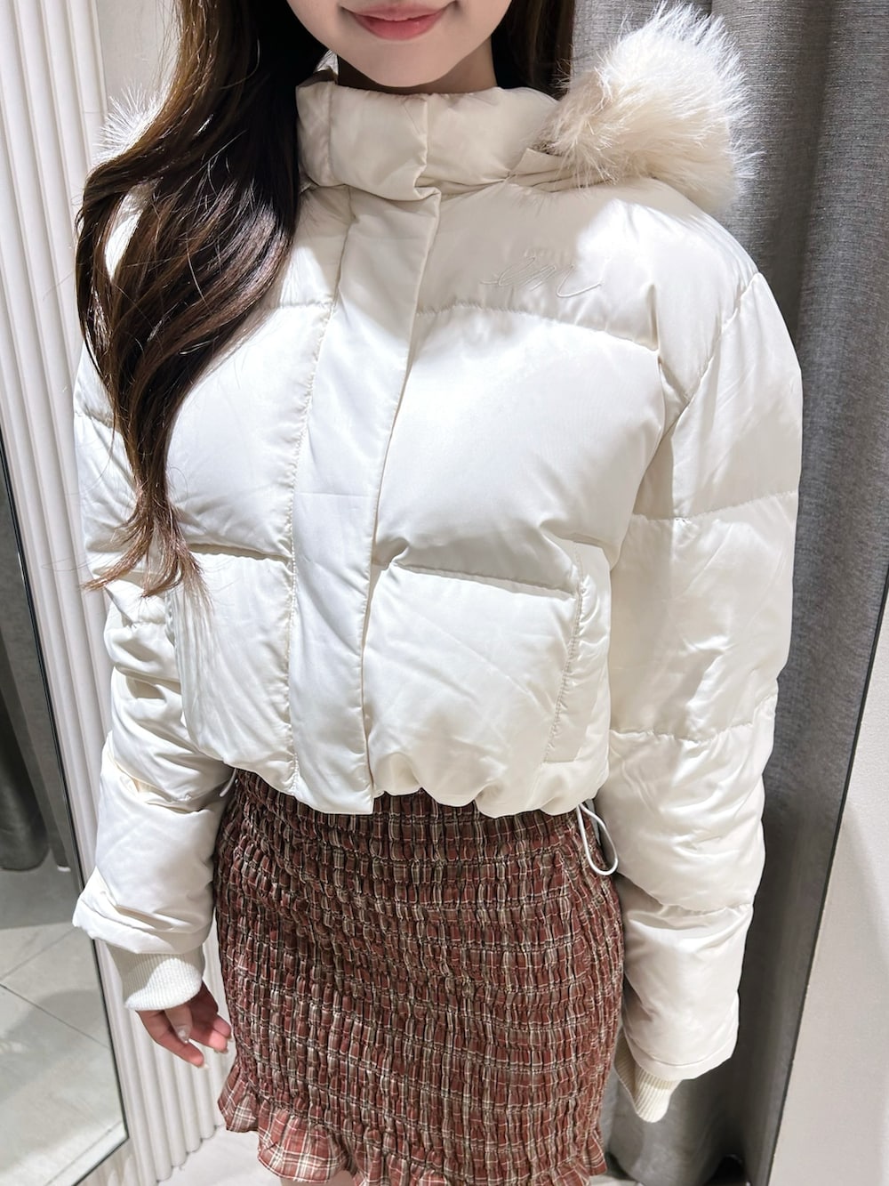 レッド系のワンピース、ホワイト系のブルゾン、ブラウン系のブーツを着用したレディースの秋コーディネートの4枚目の写真