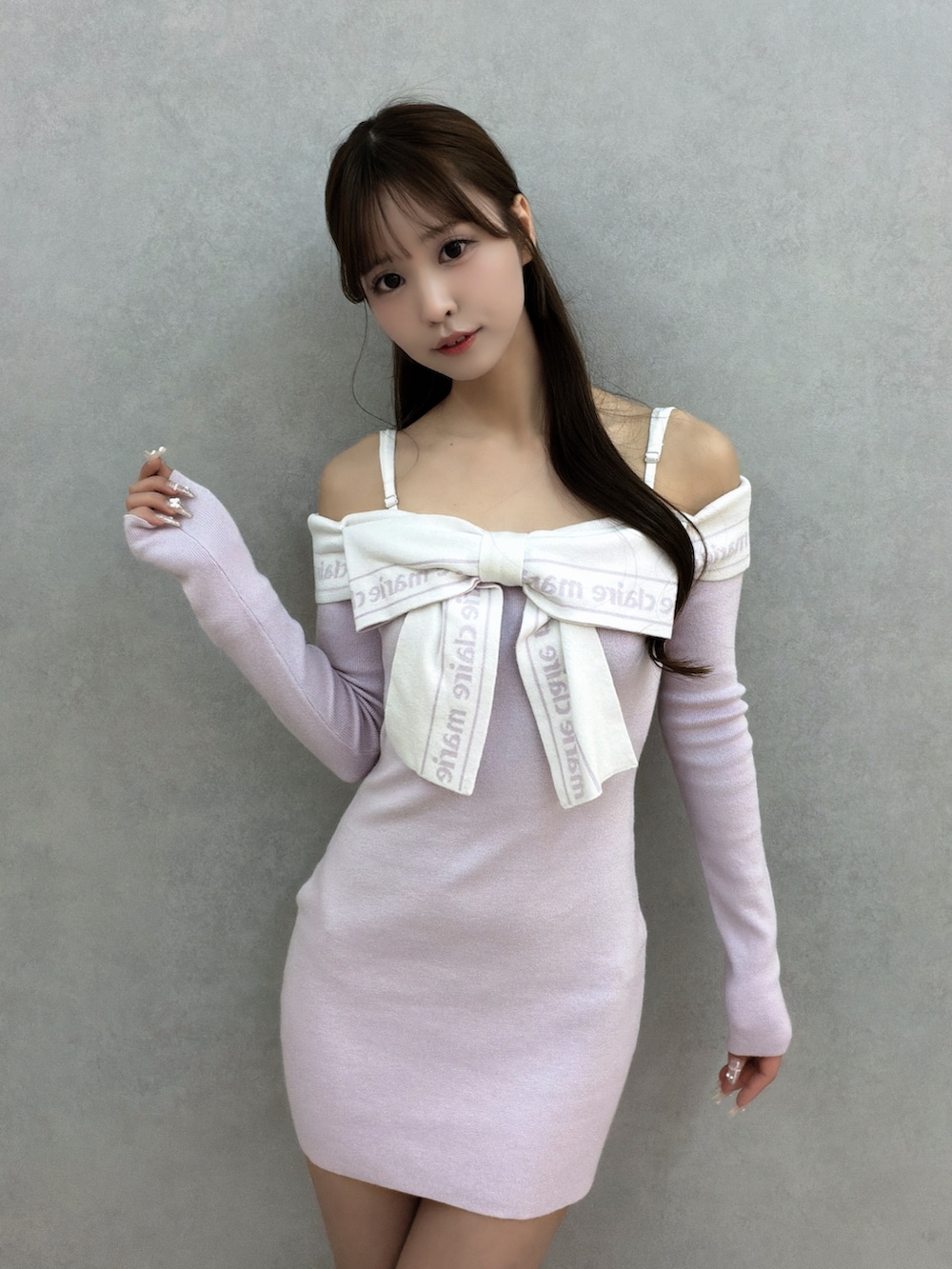 パープル系のワンピース、ブラック系のブーツを着用したレディースの冬コーディネートの5枚目の写真