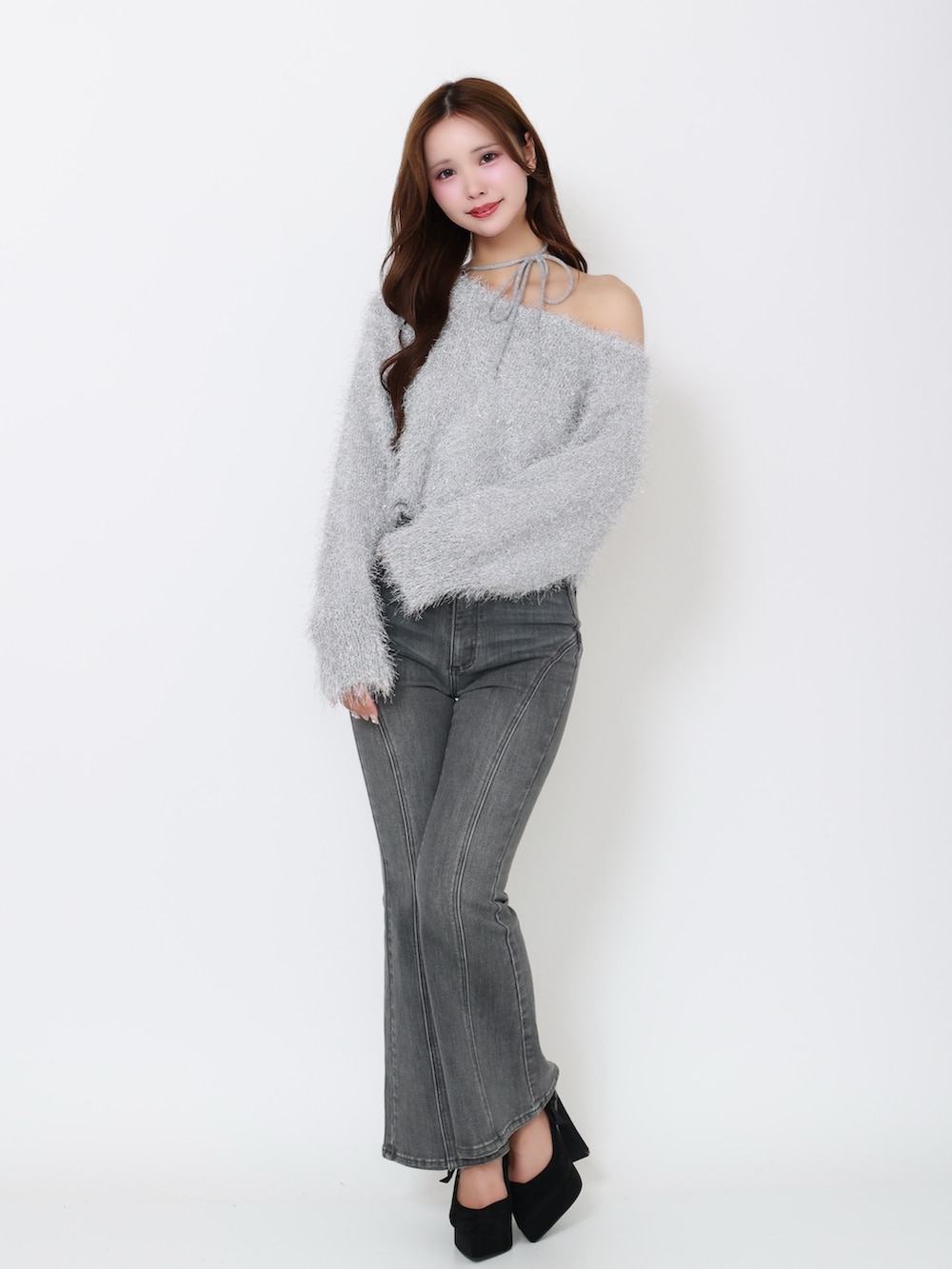 グレー系のニット/セーター、ブラック系のデニムパンツを着用したレディースの冬コーディネートの2枚目の写真