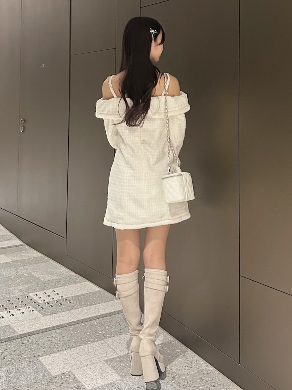 ホワイト系のワンピース、ホワイト系のハンドバッグ、ホワイト系のブーツを着用したレディースの冬コーディネートの3枚目の写真