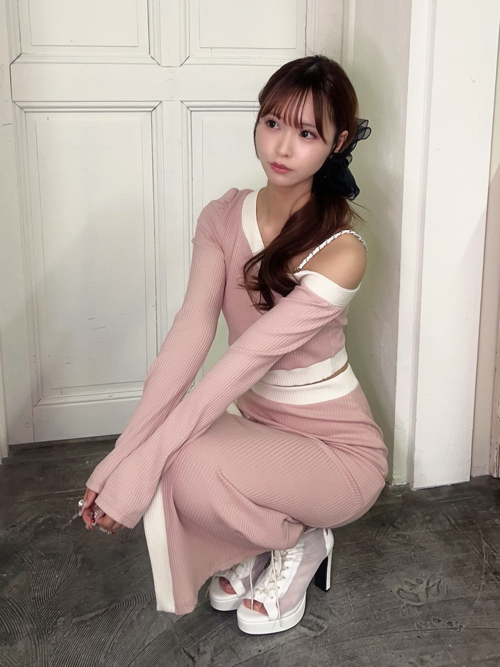 ピンク系のスカート、ピンク系のTシャツ/カットソー、ホワイト系のブーツを着用したレディースの冬コーディネートの5枚目の写真