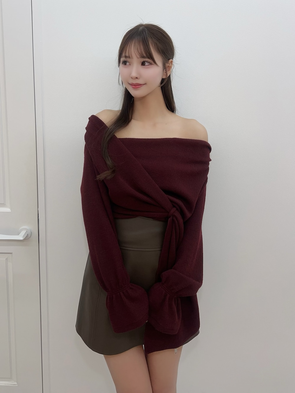 レッド系のTシャツ/カットソー、ブラウン系のスカート、ブラック系のブーツを着用したレディースの冬コーディネートの5枚目の写真