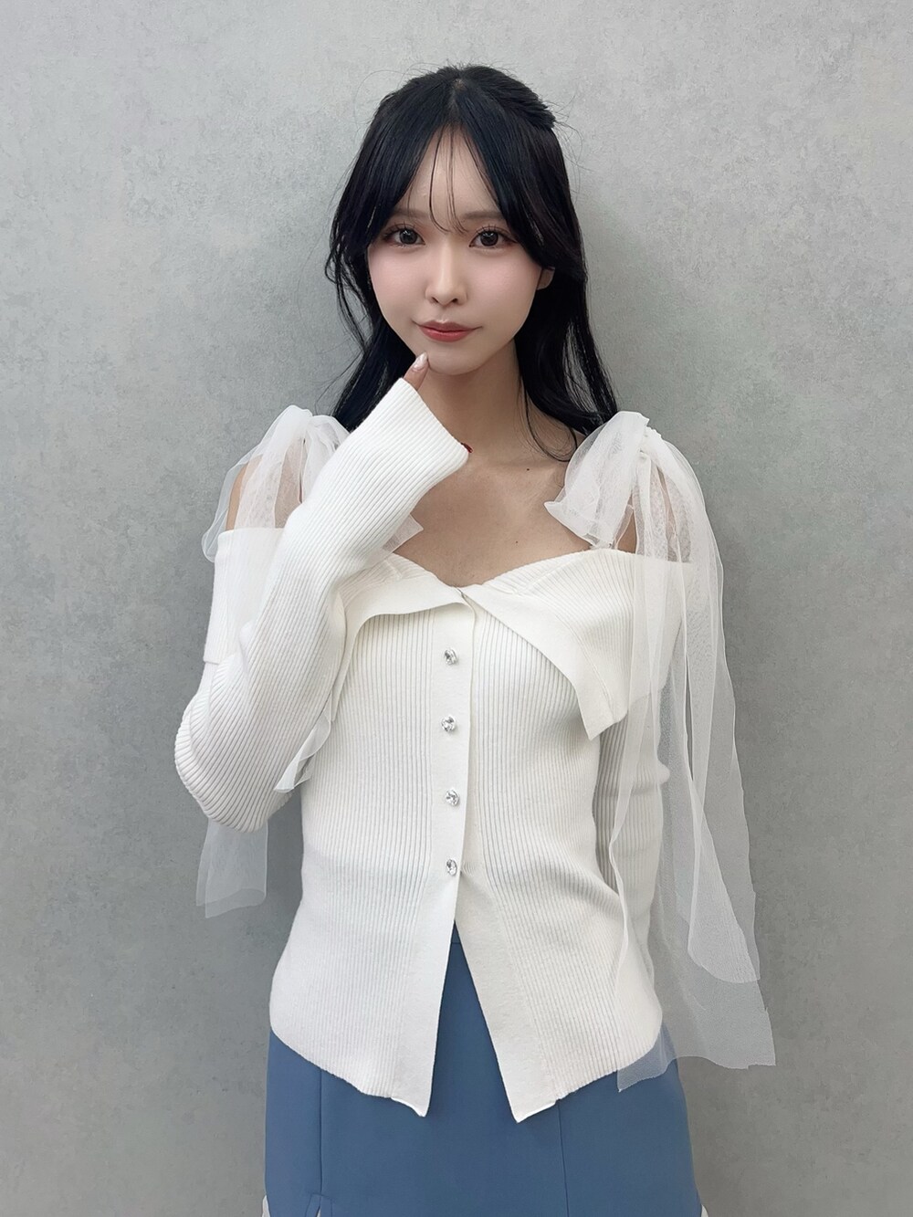 ホワイト系のニット/セーター、ブルー系のスカート、ホワイト系のブーツを着用したレディースの冬コーディネートの5枚目の写真