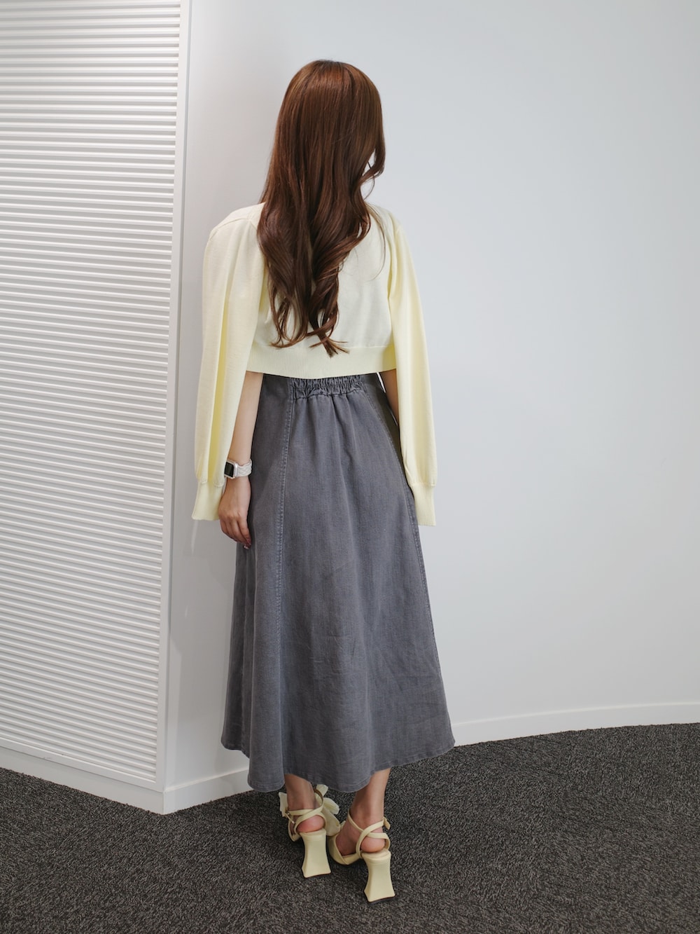 ブラック系のワンピース、イエロー系のパンプス、イエロー系のニット/セーターを着用したレディースの夏コーディネートの3枚目の写真