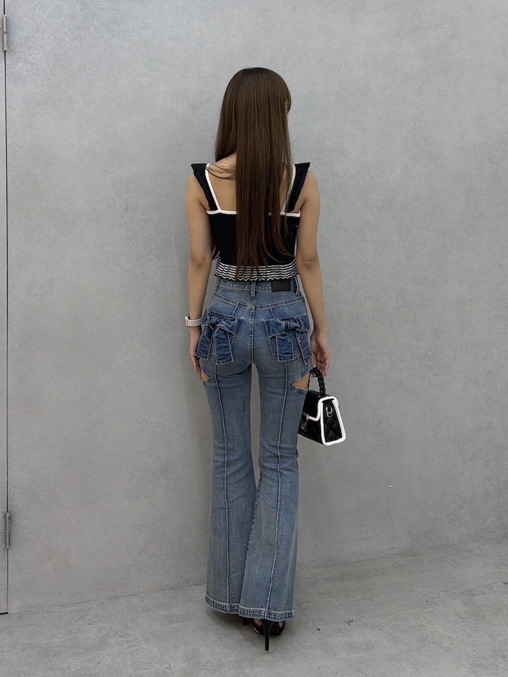 ブルー系のデニムパンツ、ブラック系のキャミソールを着用したレディースの夏コーディネートの4枚目の写真
