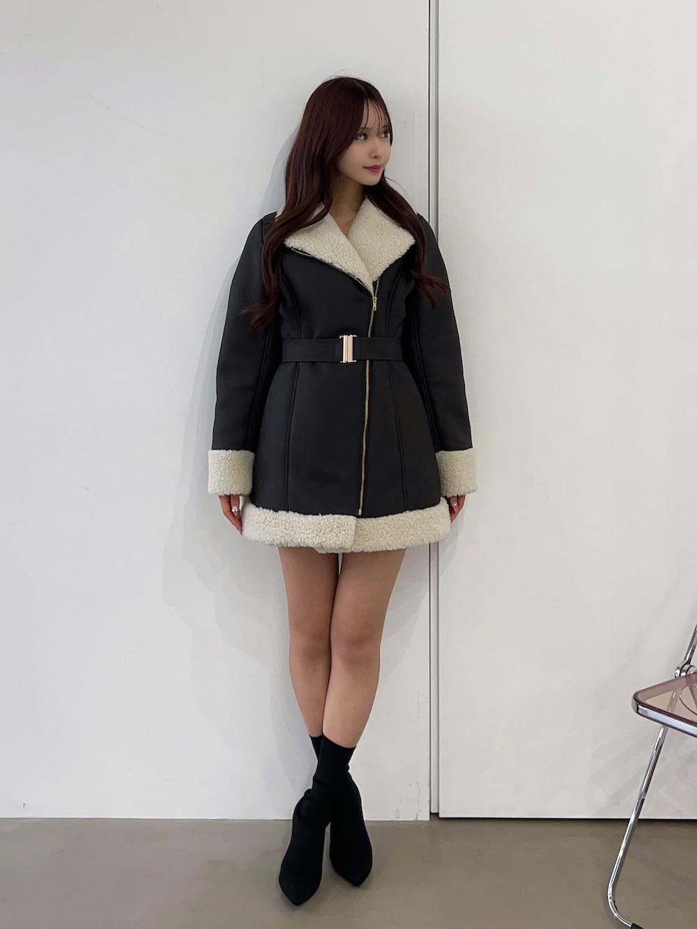 ブラウン系のムートンコート、ブラック系のブーツを着用したレディースの冬コーディネートの2枚目の写真