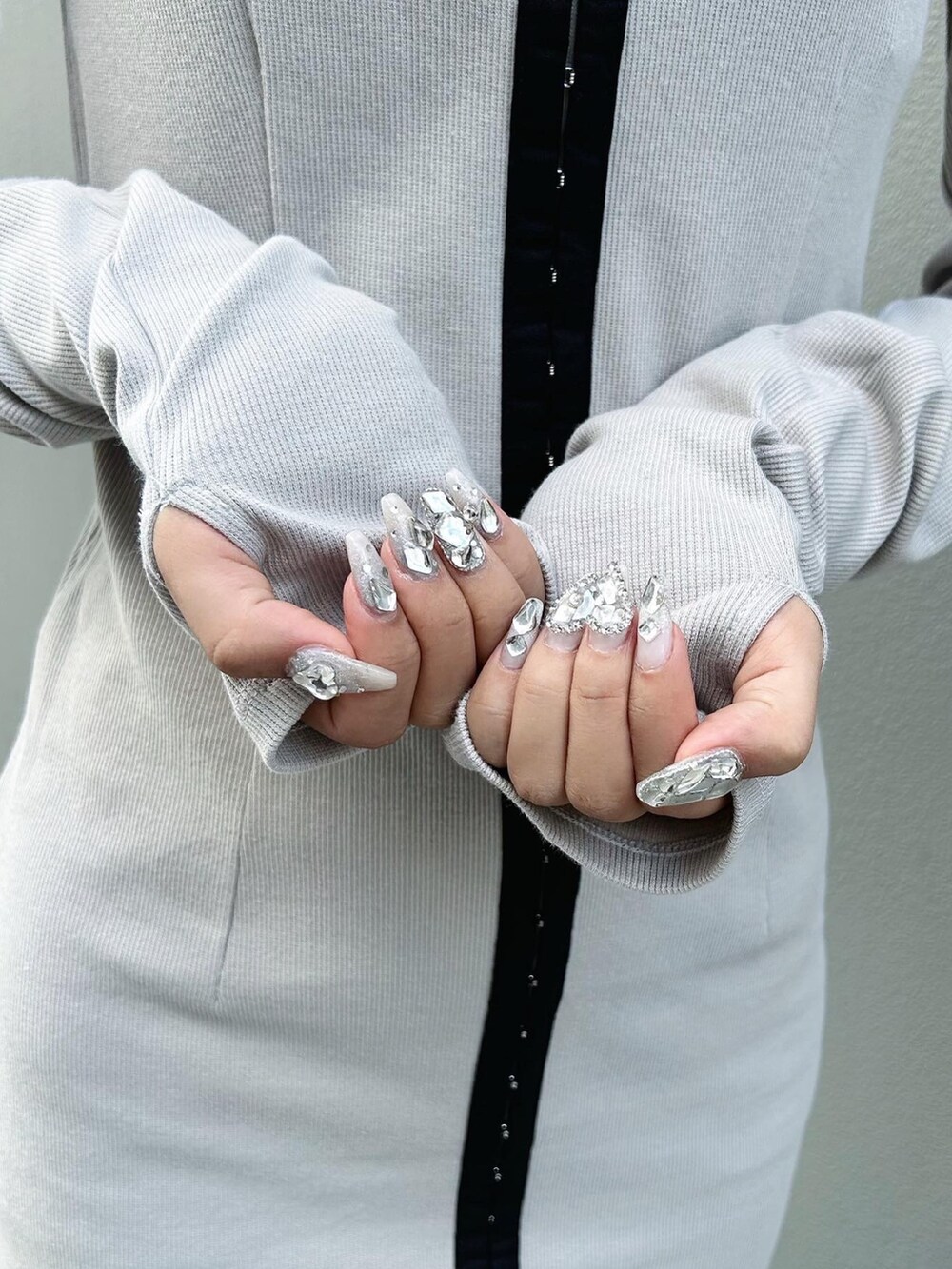 グレー系のワンピース、ブラック系のショルダーバッグ、ブラック系のブーツを着用したレディースの秋コーディネートの5枚目の写真