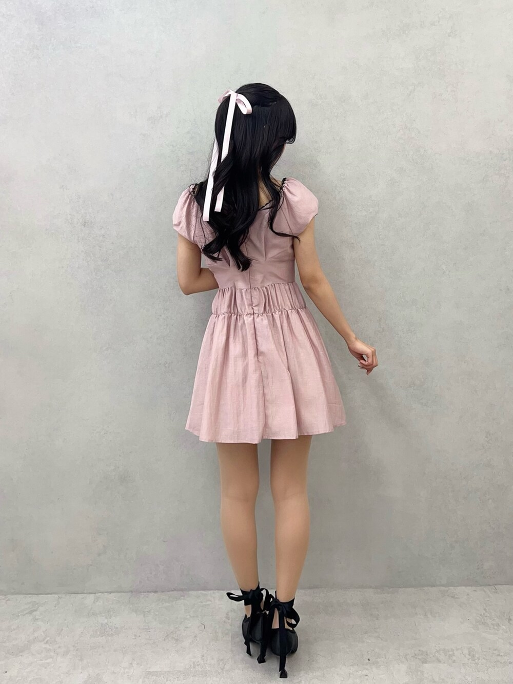 ピンク系のワンピース、ブラック系のパンプスを着用したレディースの冬コーディネートの7枚目の写真