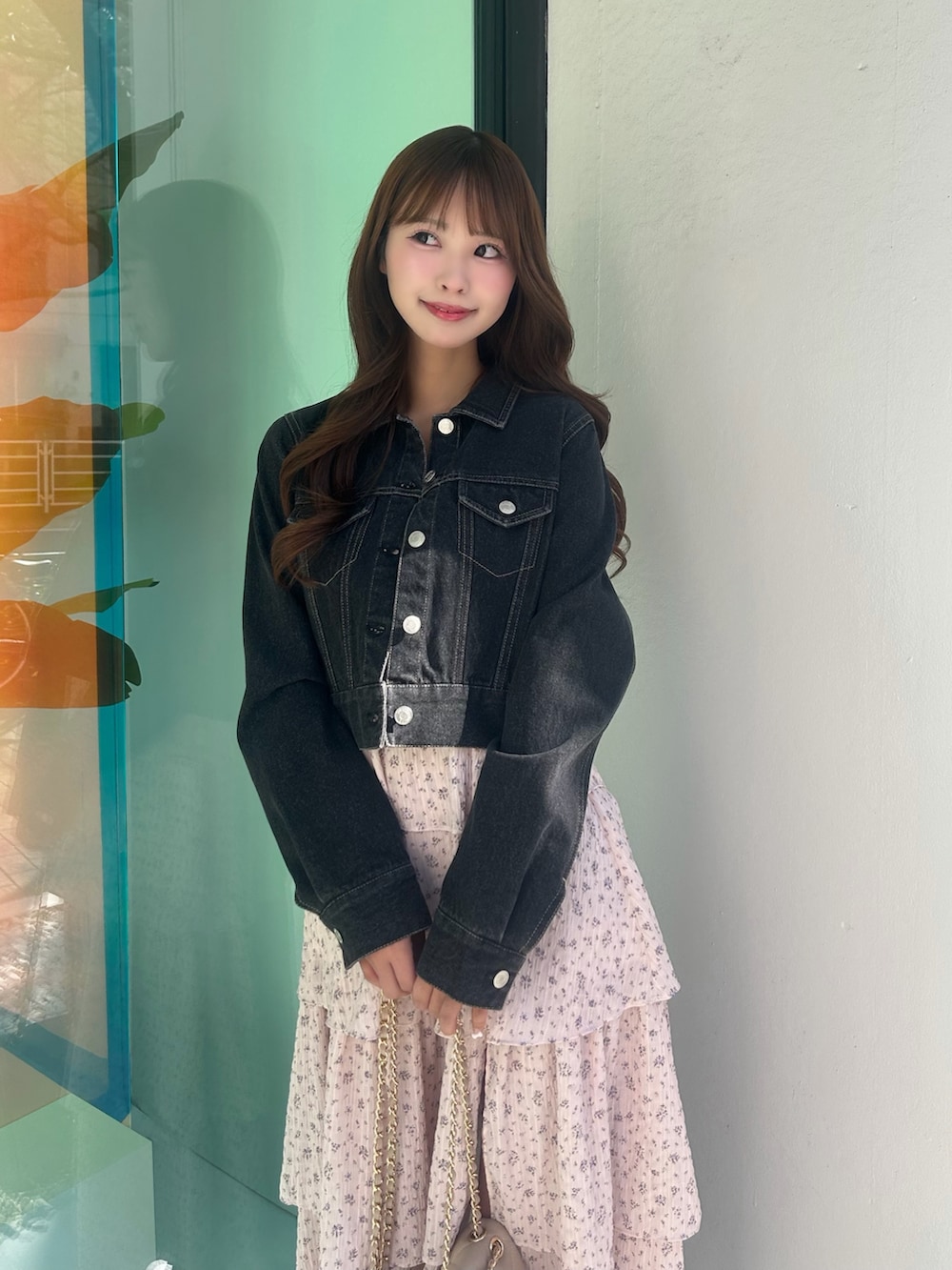 ピンク系のワンピース、ブラック系のデニムジャケット、ベージュ系のバックパック/リュックを着用したレディースの春コーディネートの6枚目の写真