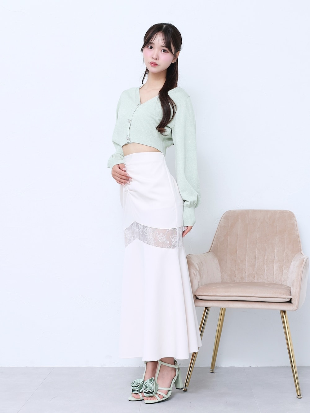 ホワイト系のスカート、グリーン系のニット/セーター、グリーン系のサンダルを着用したレディースの春コーディネートの3枚目の写真