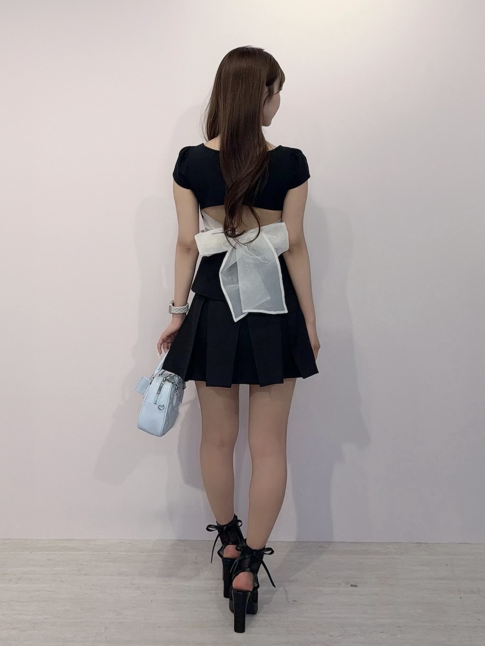 ブラック系のTシャツ/カットソー、ブラック系のスカート、ブラック系のハンドバッグを着用したレディースの春コーディネートの4枚目の写真