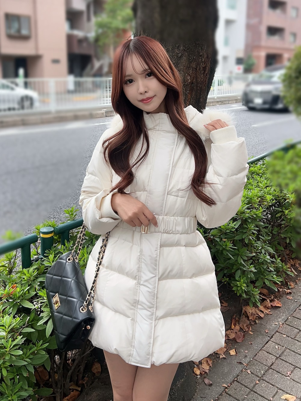 ホワイト系のダウンジャケット/コート、ブラック系のブーツ、ブラック系のハンドバッグを着用したレディースの秋コーディネートの5枚目の写真