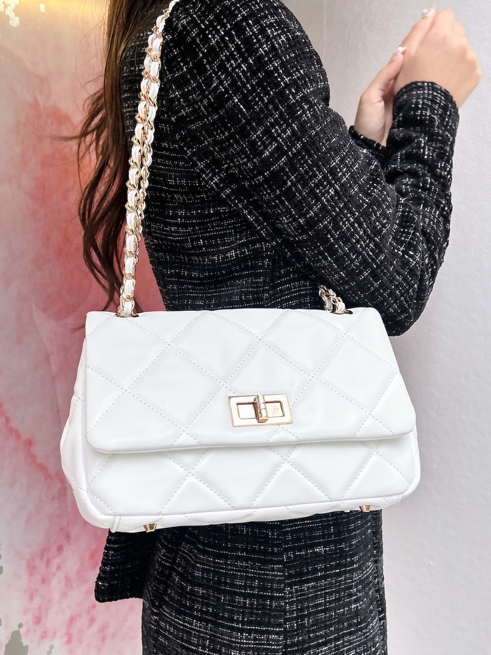 ブラック系のワンピース、ホワイト系のハンドバッグ、ブラック系のブーツを着用したレディースの秋コーディネートの6枚目の写真