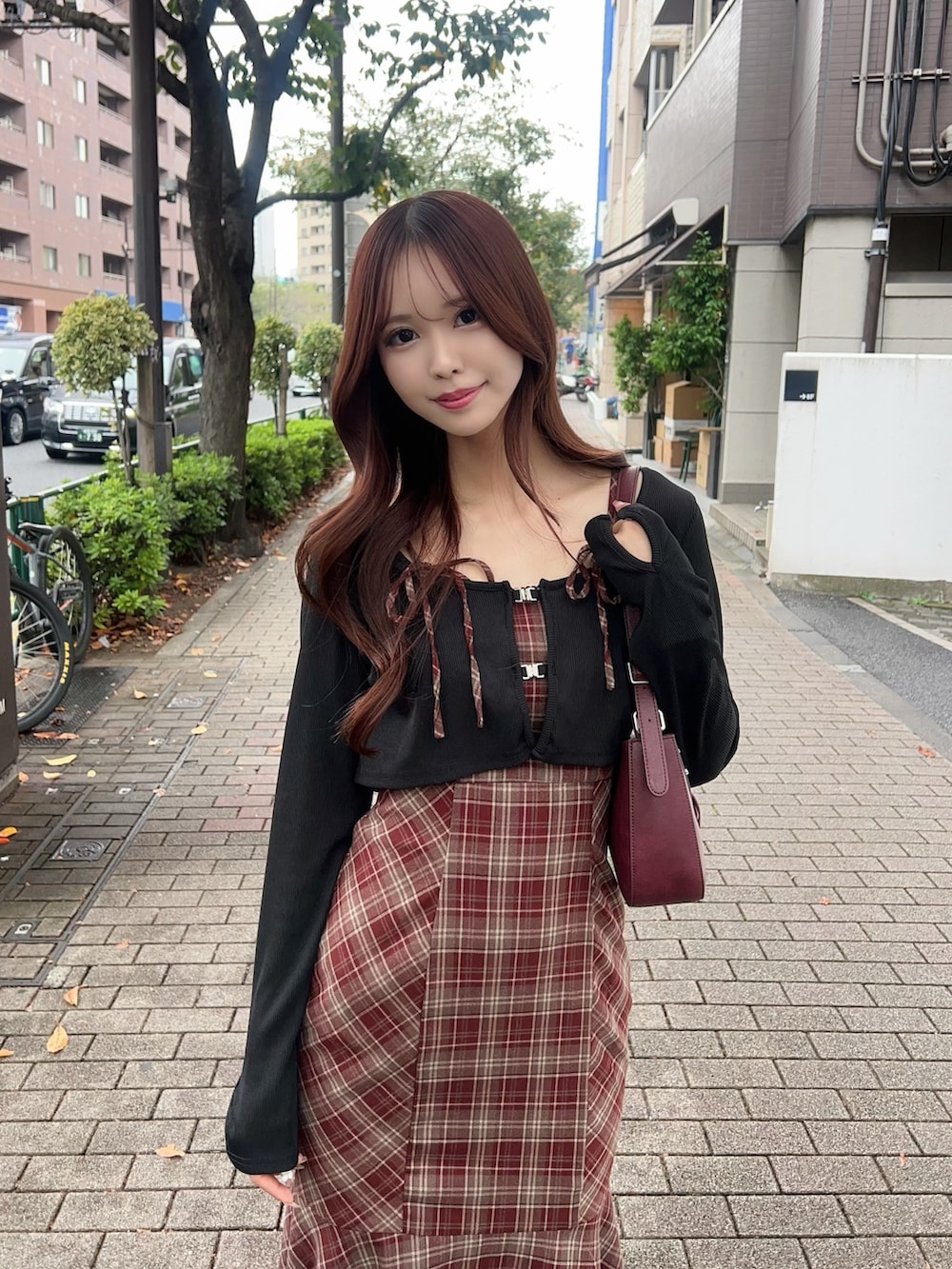 レッド系のワンピース、ブラック系のブーツ、レッド系のショルダーバッグを着用したレディースの秋コーディネートの4枚目の写真