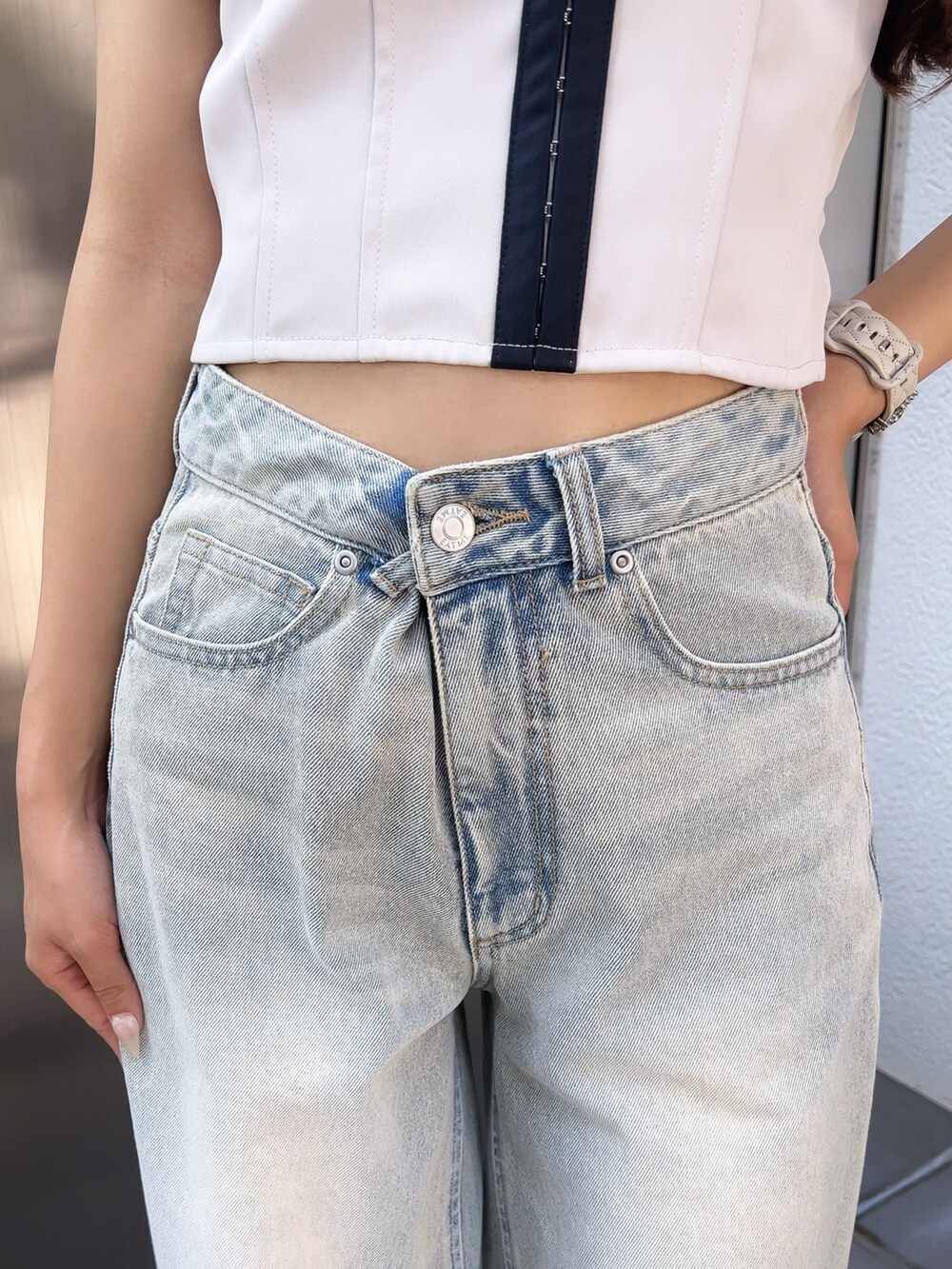ホワイト系のキャミソール、ブルー系のデニムパンツ、ブラック系のパンプスを着用したレディースの夏コーディネートの5枚目の写真