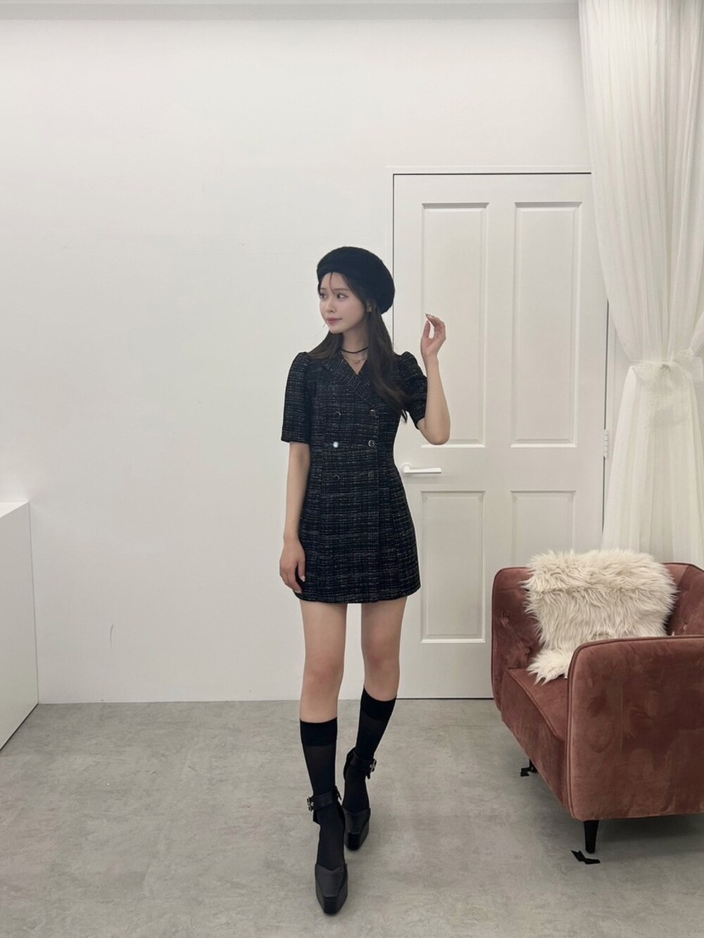 ホワイト系のハンドバッグ、ブラック系のワンピース、ブラック系のパンプスを着用したレディースの夏コーディネートの5枚目の写真