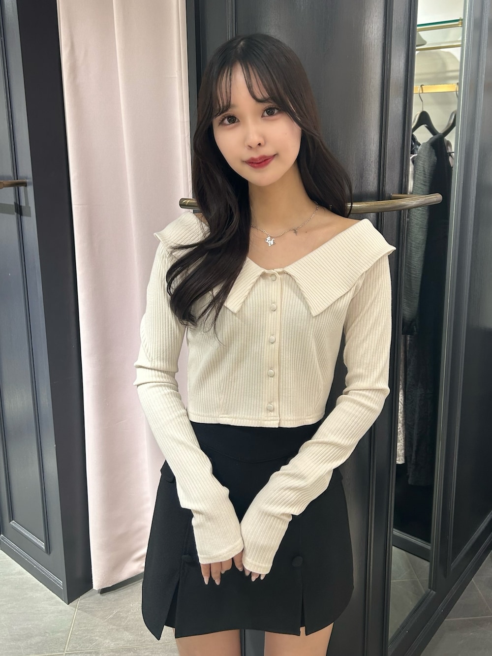 ブラック系のスカート、ホワイト系のTシャツ/カットソー、ベージュ系のローファーを着用したレディースの冬コーディネートの2枚目の写真