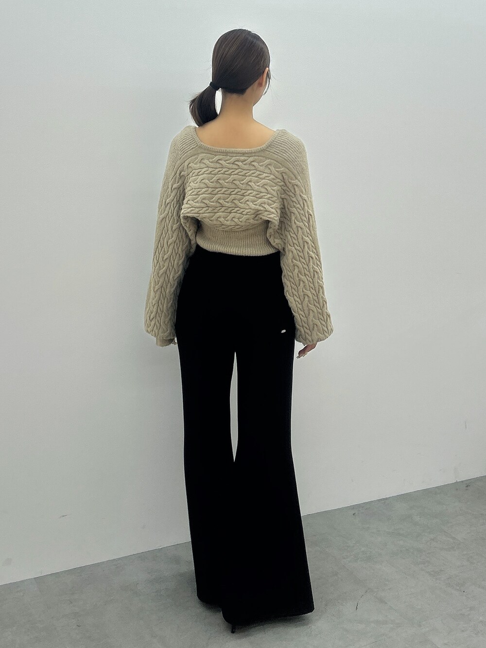 ブラック系のその他パンツ、ベージュ系のニット/セーター、ブラック系のブーツを着用したレディースの冬コーディネートの4枚目の写真