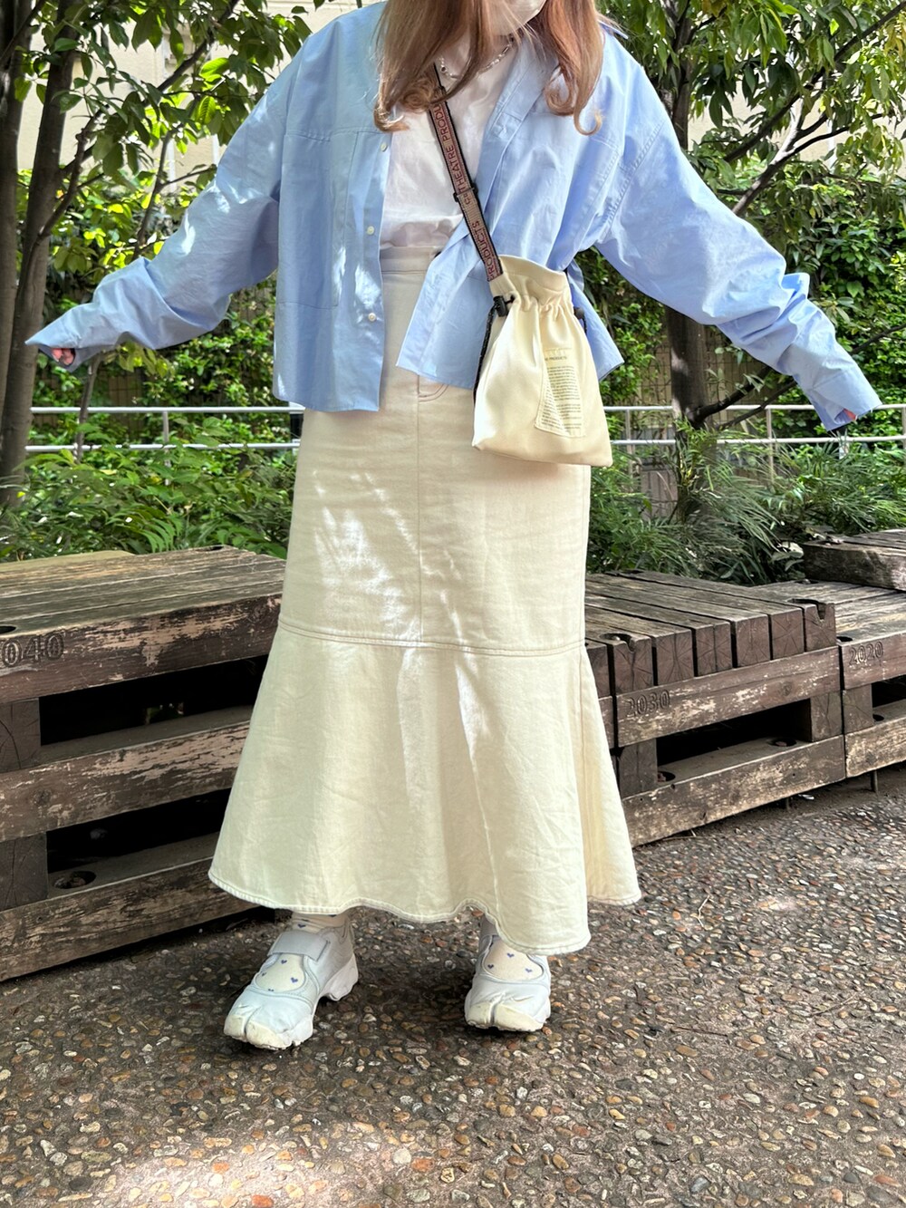 ホワイト系のショルダーバッグ、ブルー系のシャツ/ブラウス、ホワイト系のデニムスカートを着用したレディースの春コーディネートの2枚目の写真