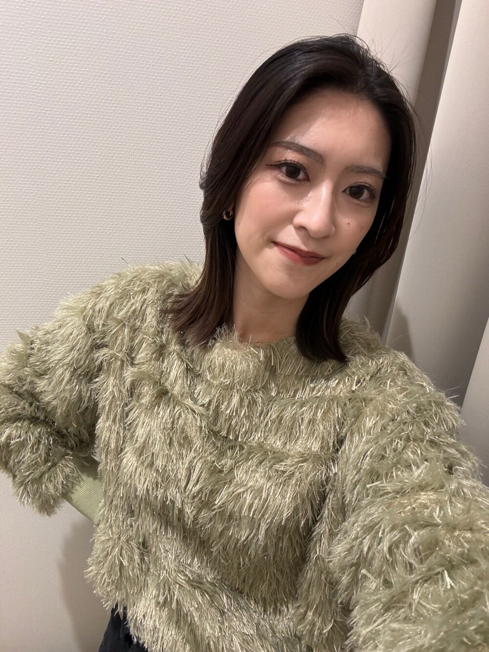 ブラック系のバッグ、ブラック系のブーツ、グリーン系のTシャツ/カットソーを着用したレディースの冬コーディネートの5枚目の写真