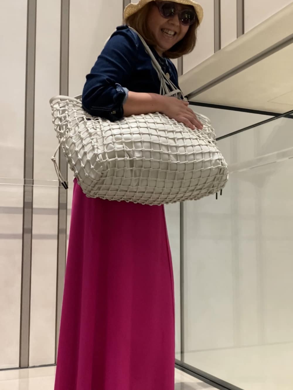 ベージュ系のトートバッグを着用したレディースの夏コーディネートの4枚目の写真