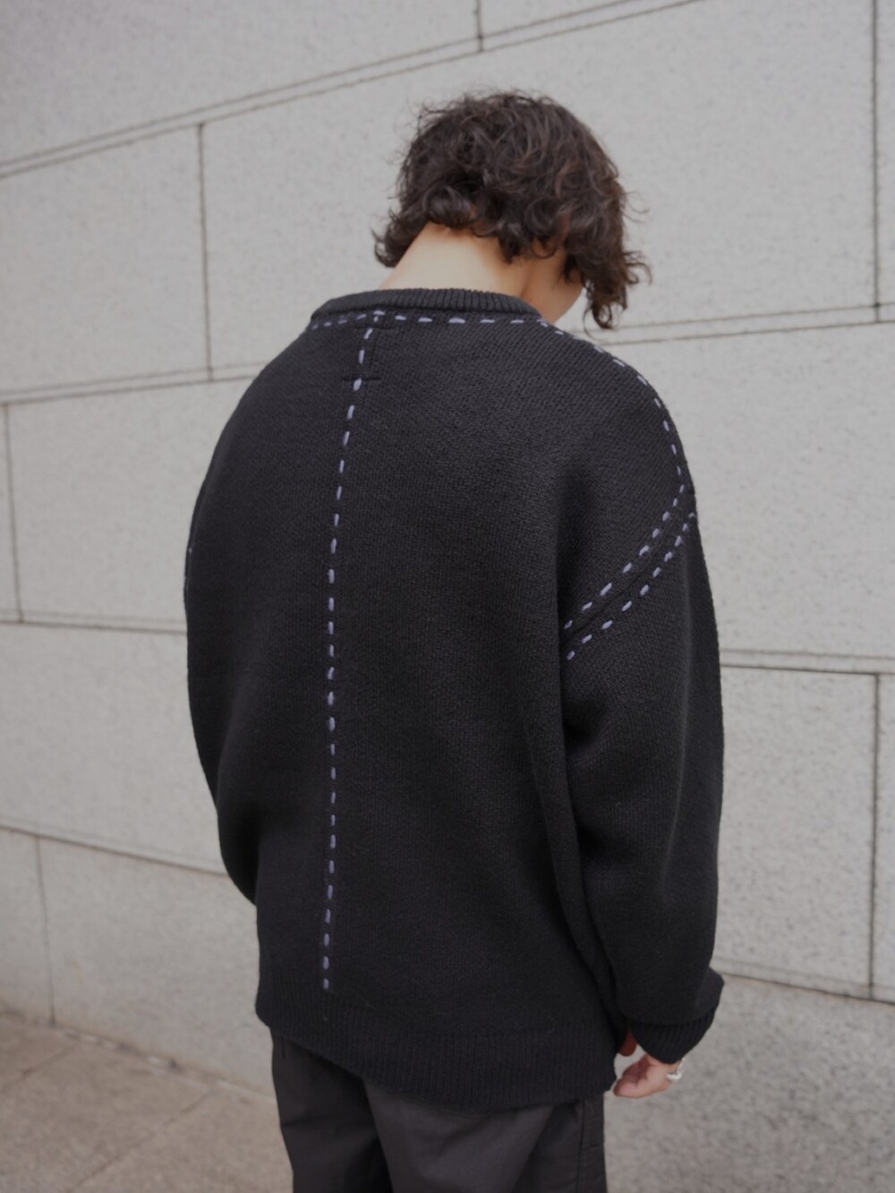 ブラック系のニット/セーター、ブラック系のサンダルを着用したメンズの秋コーディネートの3枚目の写真