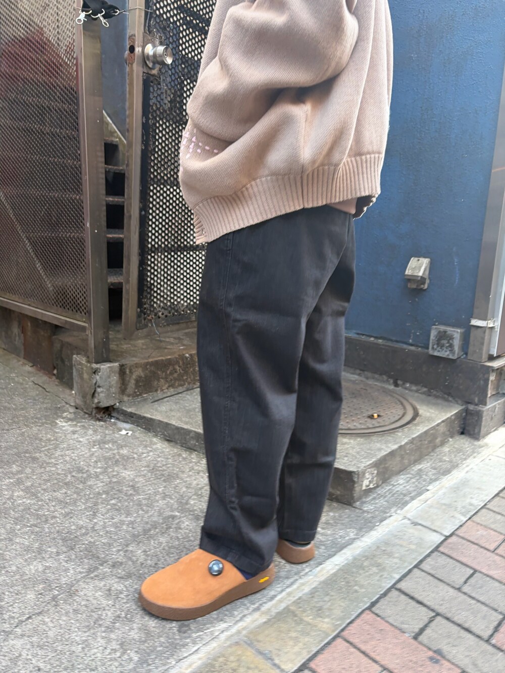 ベージュ系のカーディガン/ボレロ、ブラック系のデニムパンツ、ブラウン系のサンダルを着用したメンズの冬コーディネートの4枚目の写真