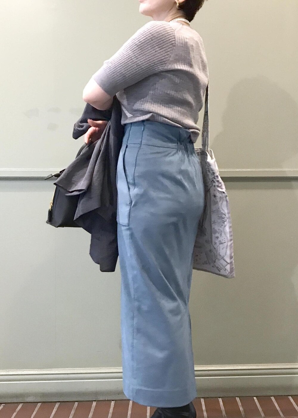 ブルー系のスカート、ホワイト系のトートバッグ、グレー系のテーラードジャケットを着用したレディースの秋コーディネートの5枚目の写真