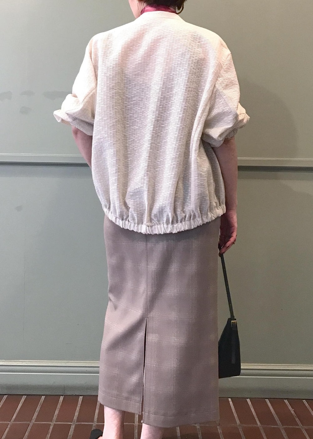 ブラック系のパンプス、レッド系のキャミソール、ブラック系のハンドバッグを着用したレディースの夏コーディネートの4枚目の写真