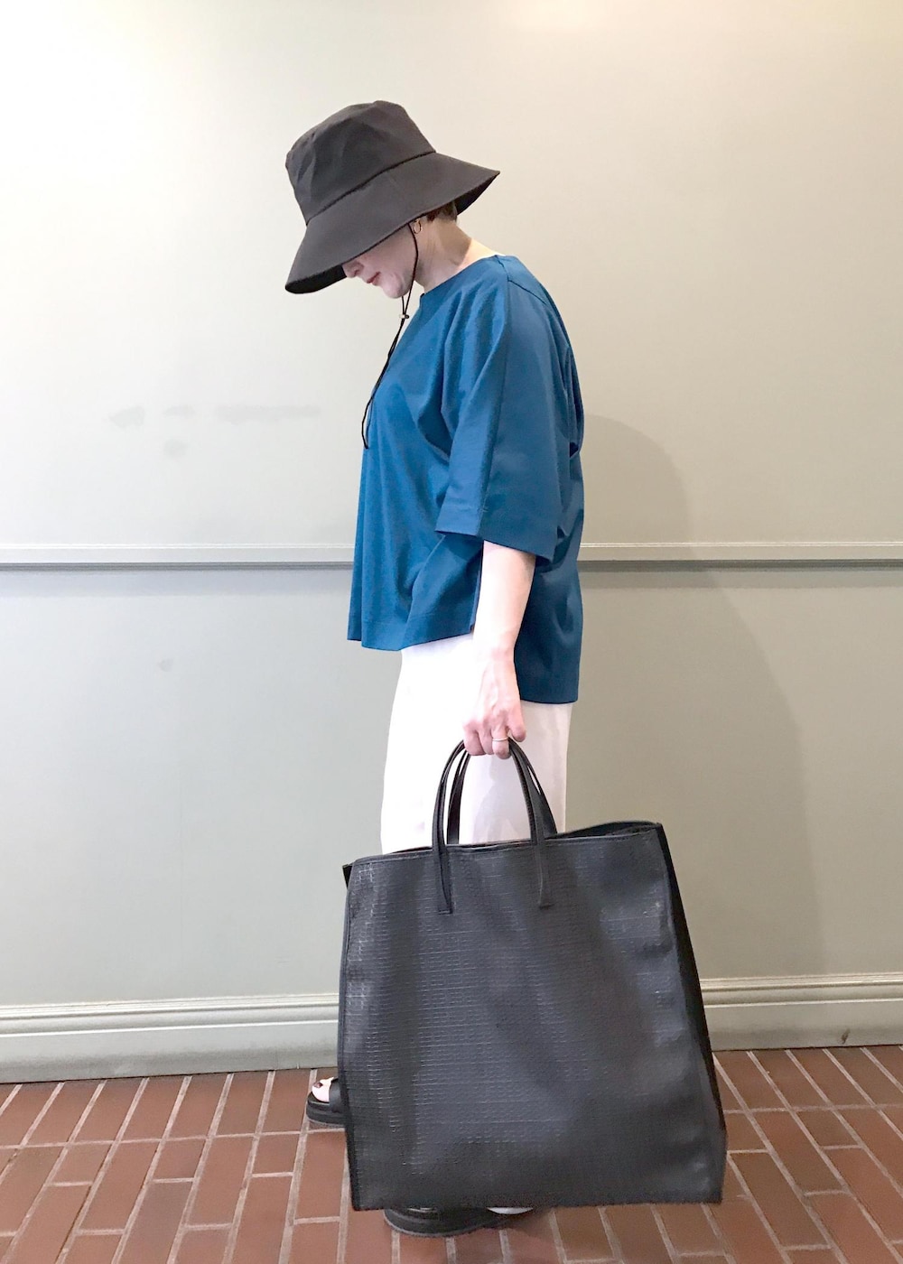 ホワイト系のその他パンツ、ブラック系のトートバッグ、ブラック系のサンダルを着用したレディースの夏コーディネートの3枚目の写真