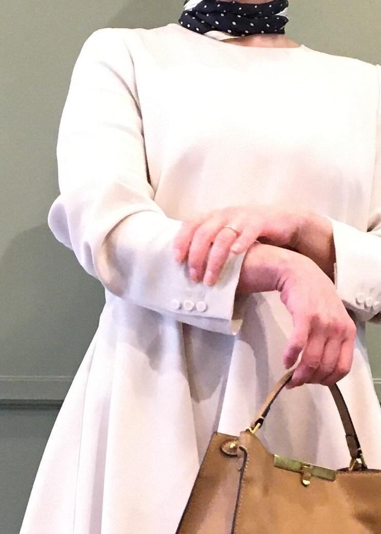 ブラック系のパンプス、ベージュ系のショルダーバッグ、ベージュ系のスカートを着用したレディースの冬コーディネートの6枚目の写真