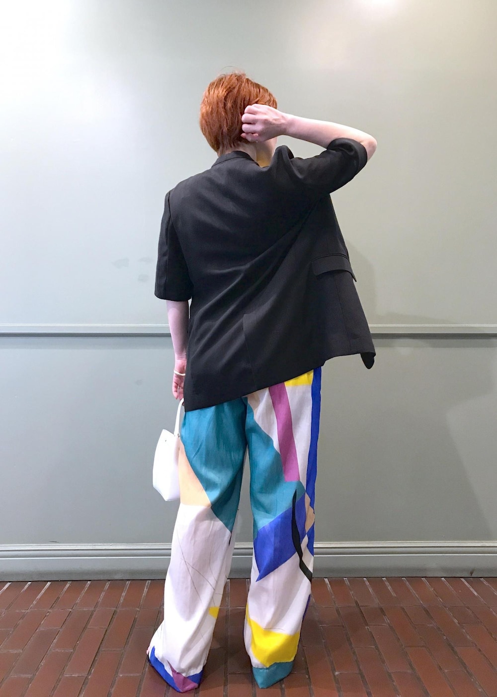 ホワイト系のハンドバッグ、ブラック系のサンダル、イエロー系のニット/セーターを着用したレディースの春コーディネートの3枚目の写真