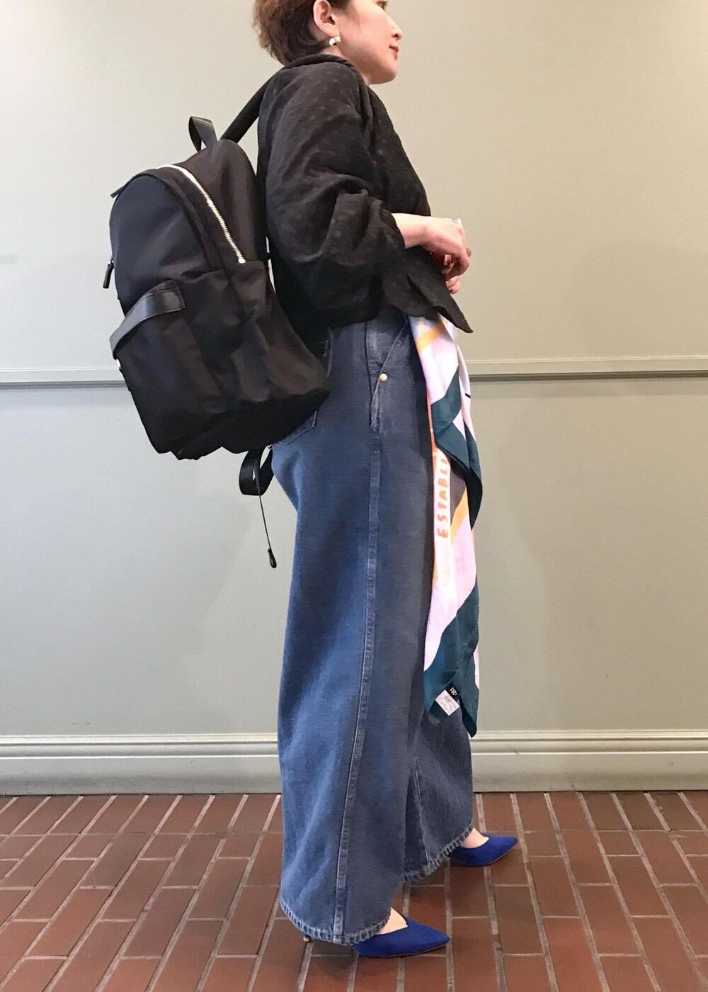 ブラック系のバックパック/リュック、ブルー系のデニムパンツ、ブラック系のシャツ/ブラウスを着用したレディースの春コーディネートの5枚目の写真
