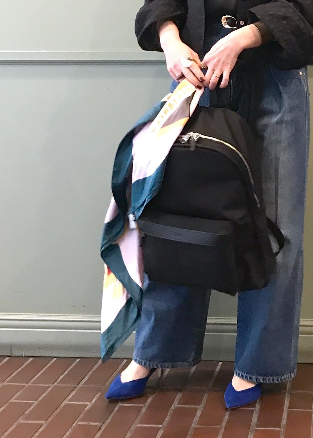 ブラック系のバックパック/リュック、ブルー系のデニムパンツ、ブラック系のシャツ/ブラウスを着用したレディースの春コーディネートの6枚目の写真