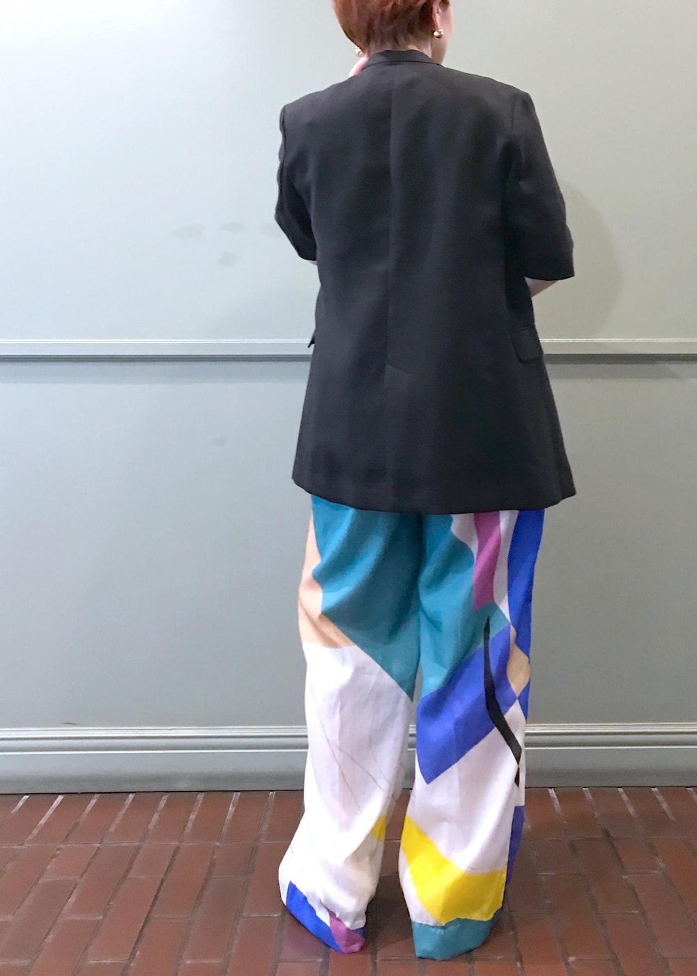 ホワイト系のハンドバッグ、ブラック系のサンダル、イエロー系のニット/セーターを着用したレディースの春コーディネートの4枚目の写真