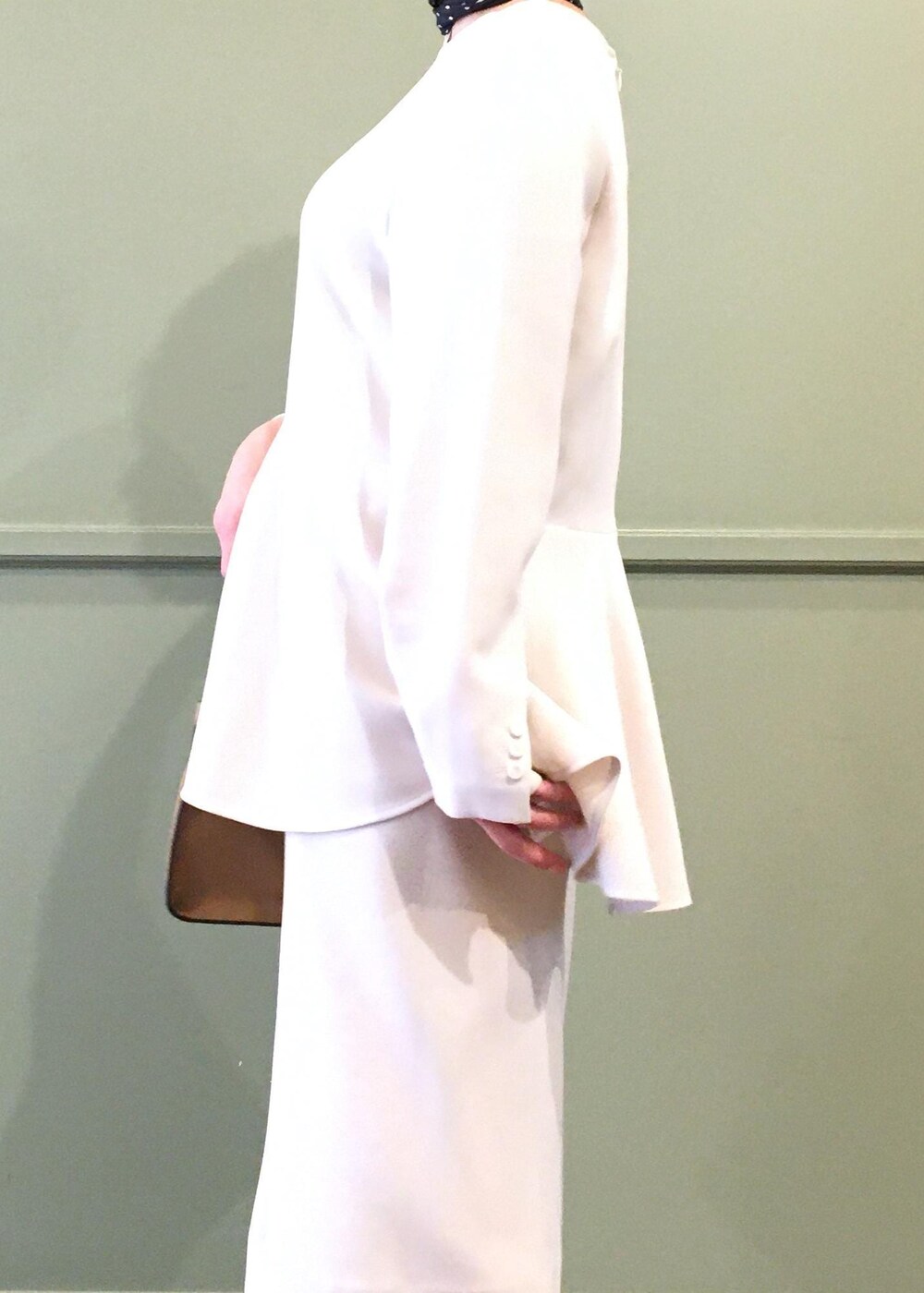 ブラック系のパンプス、ベージュ系のショルダーバッグ、ベージュ系のスカートを着用したレディースの冬コーディネートの7枚目の写真