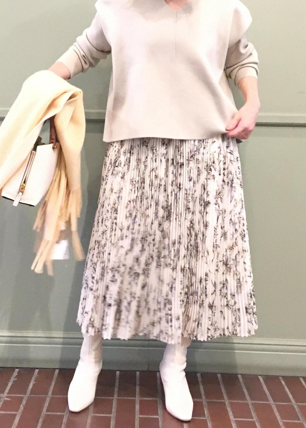 ホワイト系のハンドバッグ、ホワイト系のブーツ、ベージュ系のニット/セーターを着用したレディースの秋コーディネートの3枚目の写真