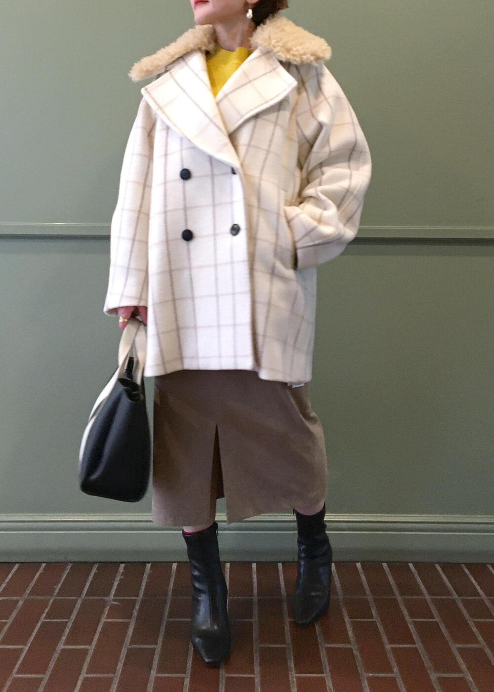 ブラック系のトートバッグ、ブラック系のブーツ、ホワイト系のチェスターコートを着用したレディースの秋コーディネートの5枚目の写真