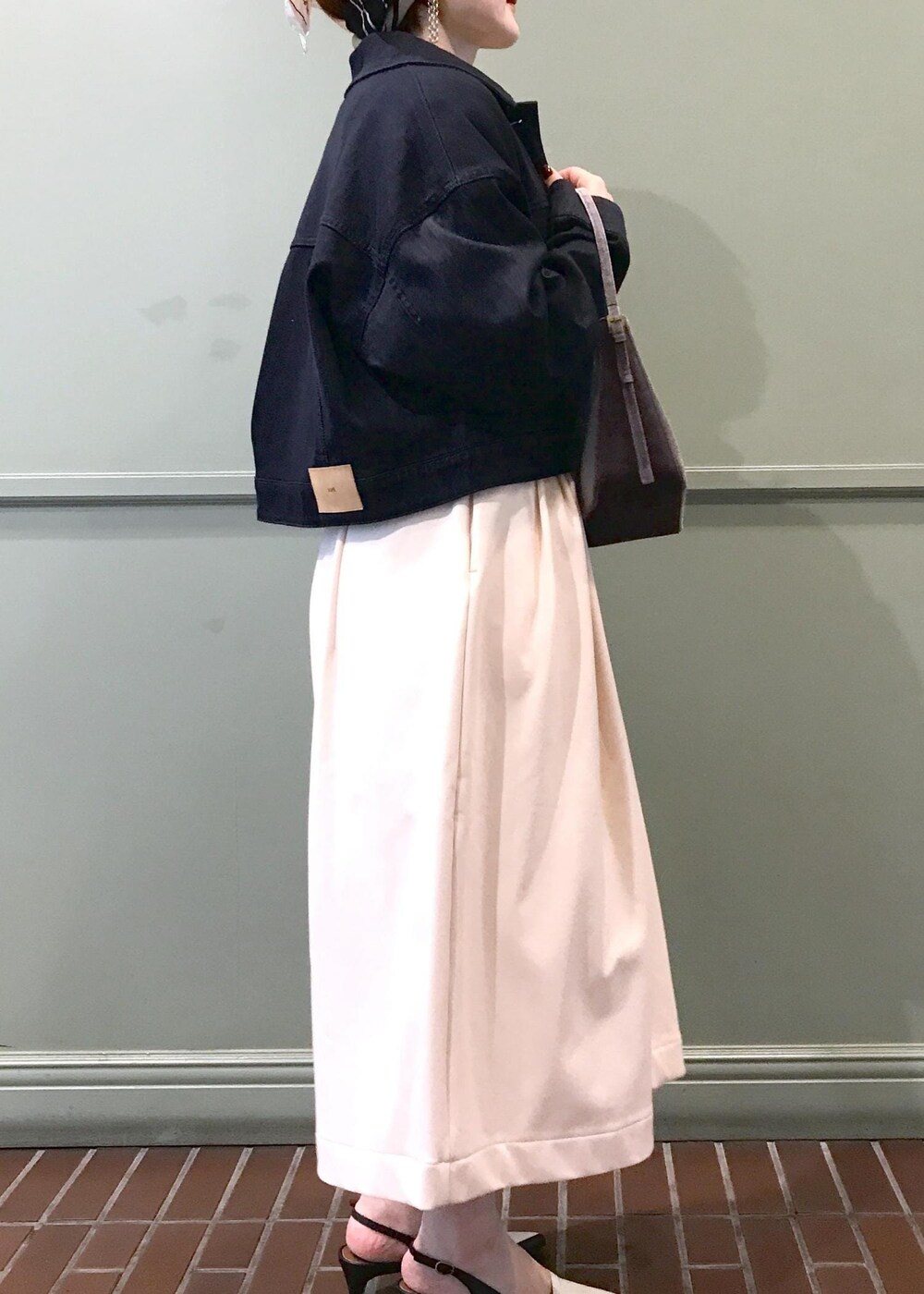 ブルー系のデニムジャケット、ベージュ系のその他パンツ、グレー系のハンドバッグを着用したレディースの夏コーディネートの3枚目の写真