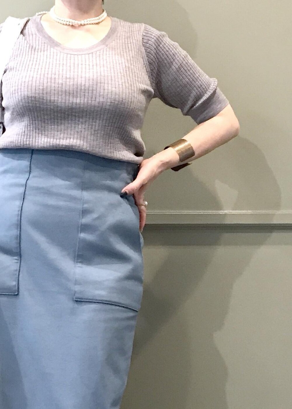 ブルー系のスカート、ホワイト系のトートバッグ、グレー系のテーラードジャケットを着用したレディースの秋コーディネートの6枚目の写真