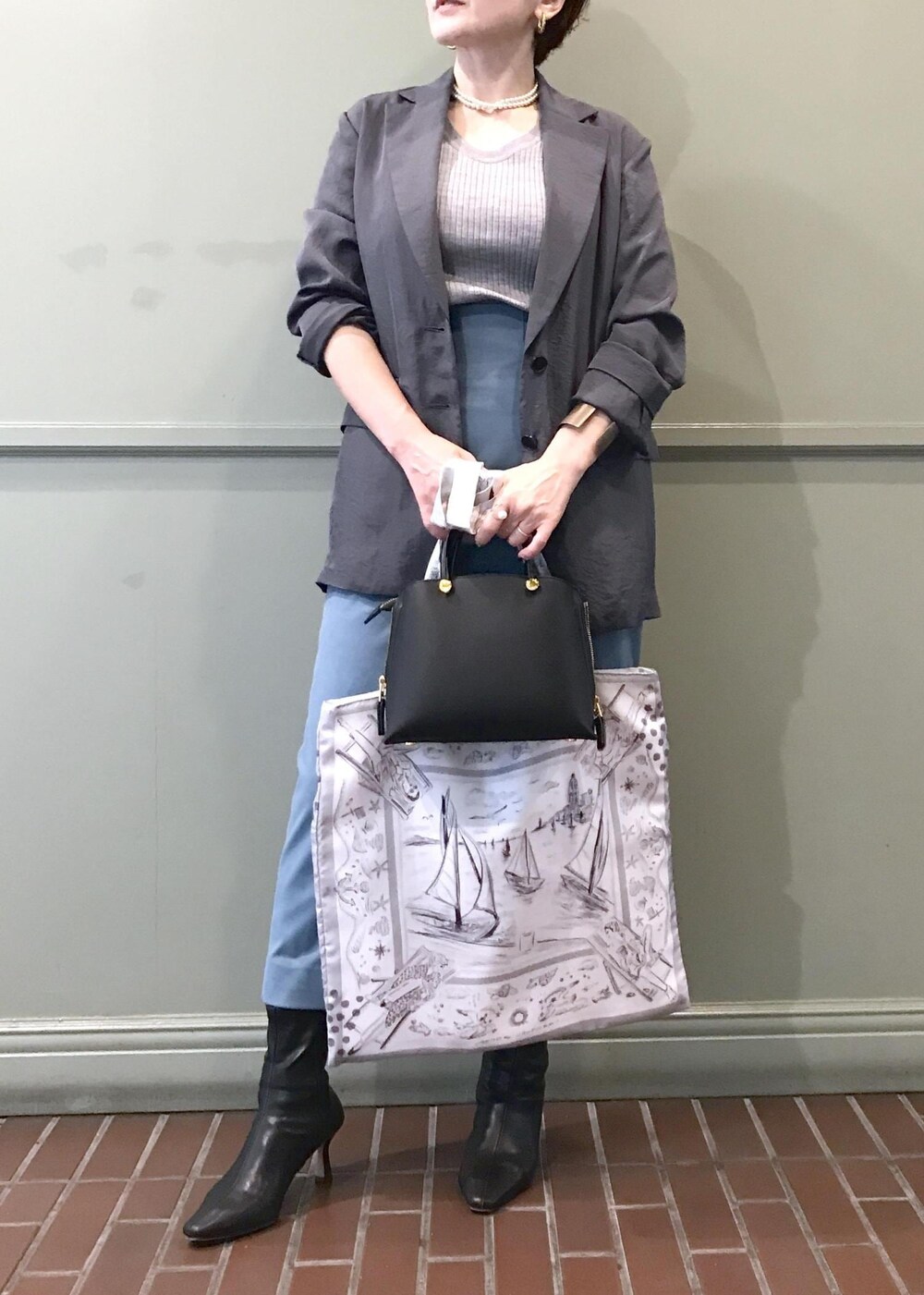 ブルー系のスカート、ホワイト系のトートバッグ、グレー系のテーラードジャケットを着用したレディースの秋コーディネートの2枚目の写真