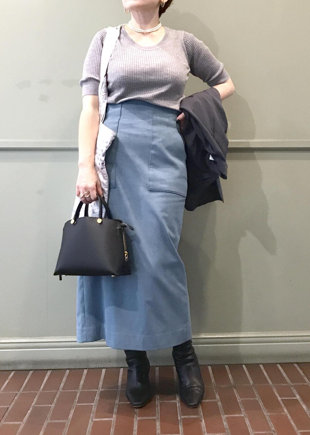 ブルー系のスカート、ホワイト系のトートバッグ、グレー系のテーラードジャケットを着用したレディースの秋コーディネートの4枚目の写真
