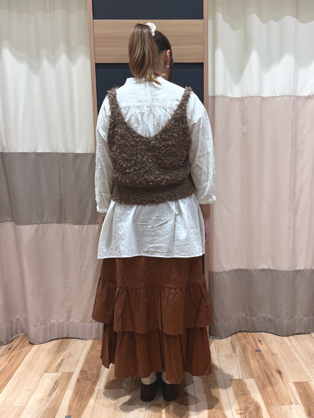 ホワイト系のシャツ/ブラウス、ブラウン系のベスト、オレンジ系のスカートを着用したレディースの秋コーディネートの2枚目の写真