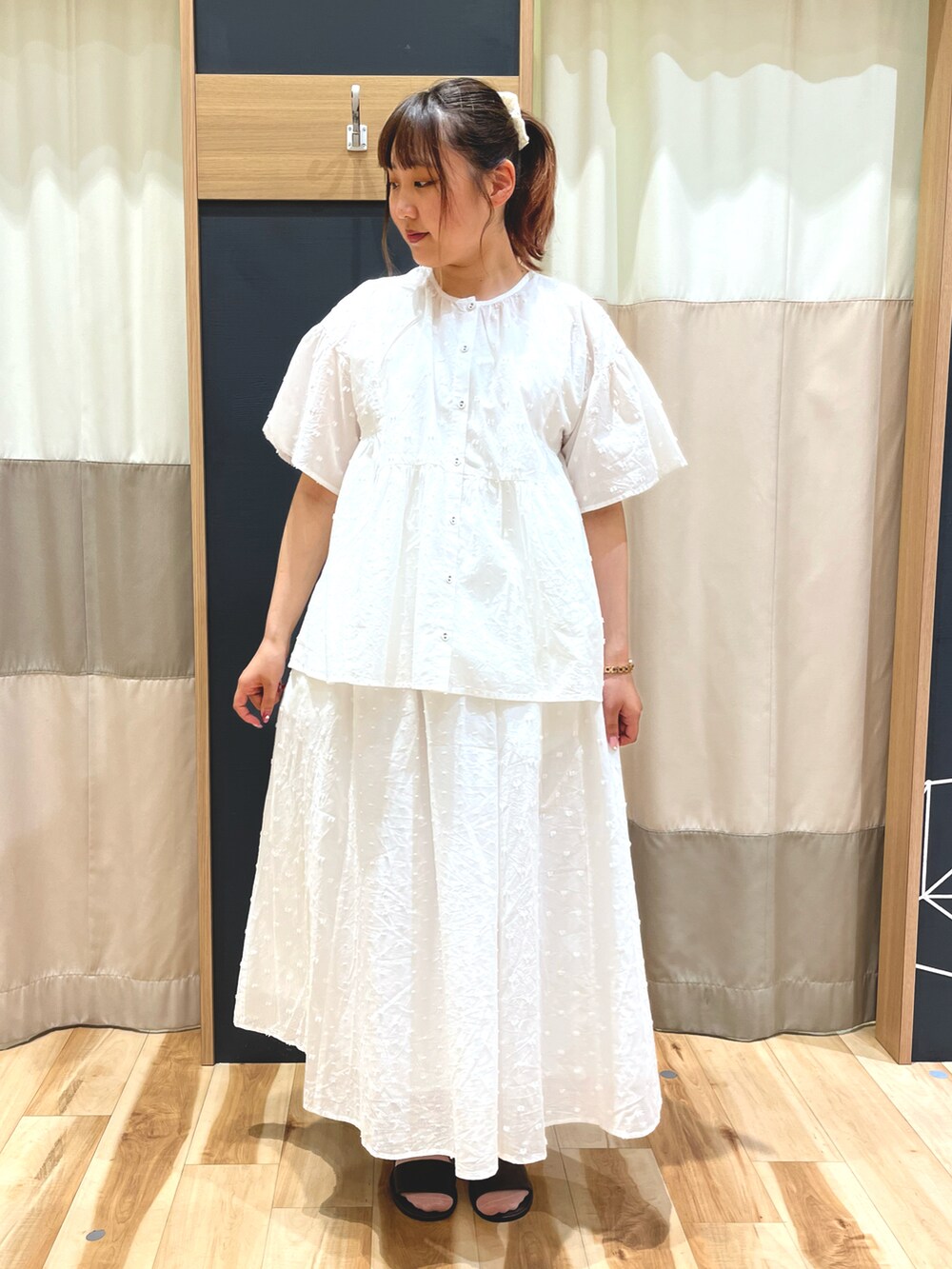 ブルー系のベスト、ホワイト系のシャツ/ブラウス、ホワイト系のスカートを着用したレディースの夏コーディネートの2枚目の写真