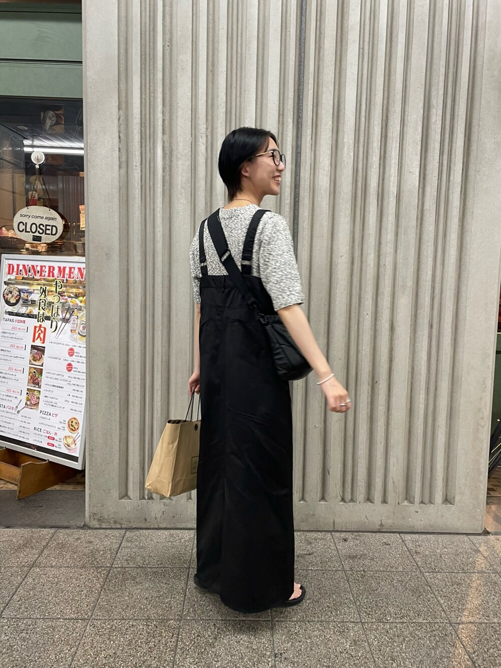 ブラック系のジャンパースカート、グレー系のニット/セーターを着用したレディースの夏コーディネートの2枚目の写真