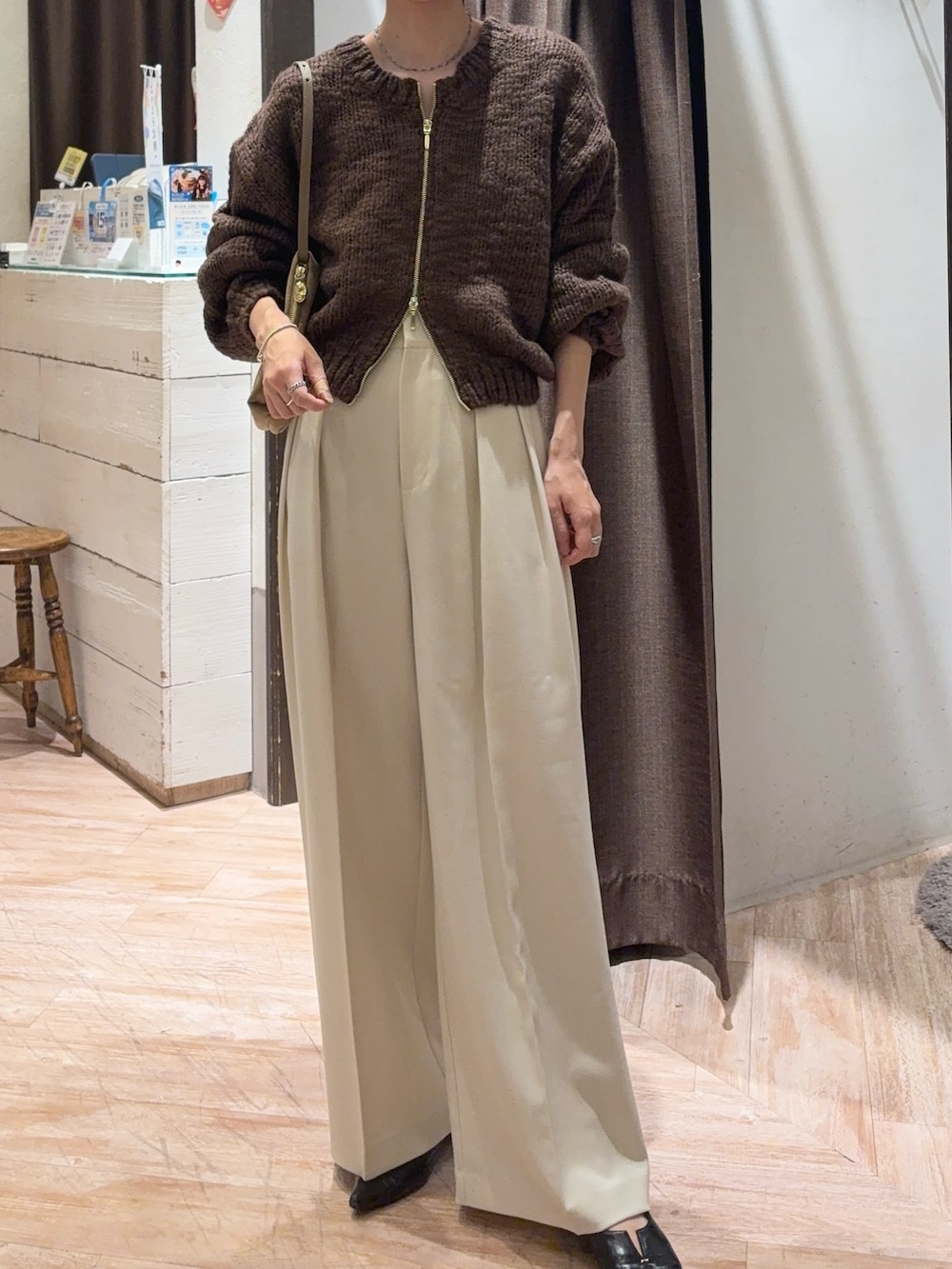 ブラウン系のニット/セーター、ホワイト系のその他パンツを着用したレディースの秋コーディネートの2枚目の写真