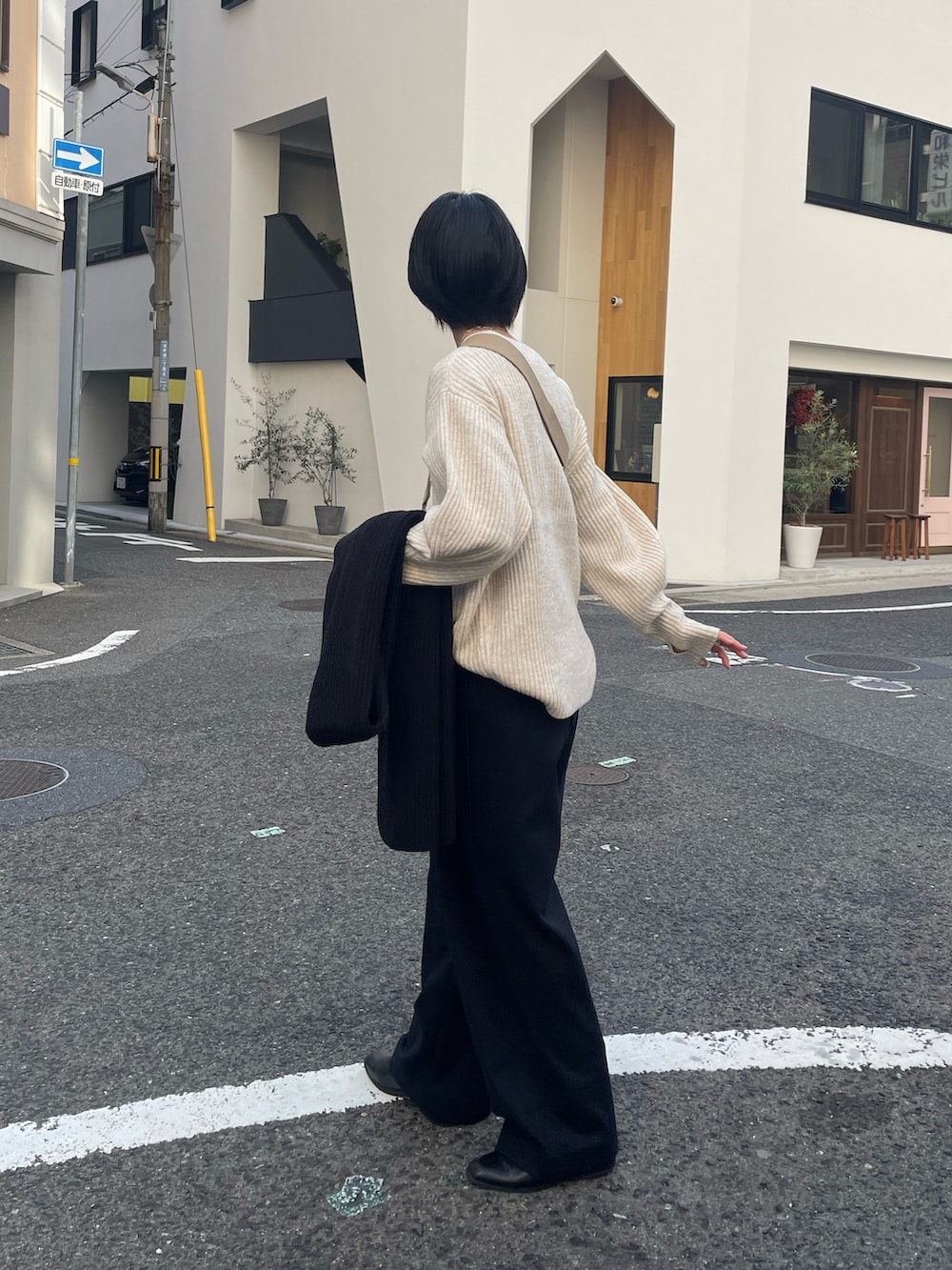 ブラック系のパンツ、ベージュ系のニット/セーター、ブラック系のマスクを着用したレディースの冬コーディネートの2枚目の写真