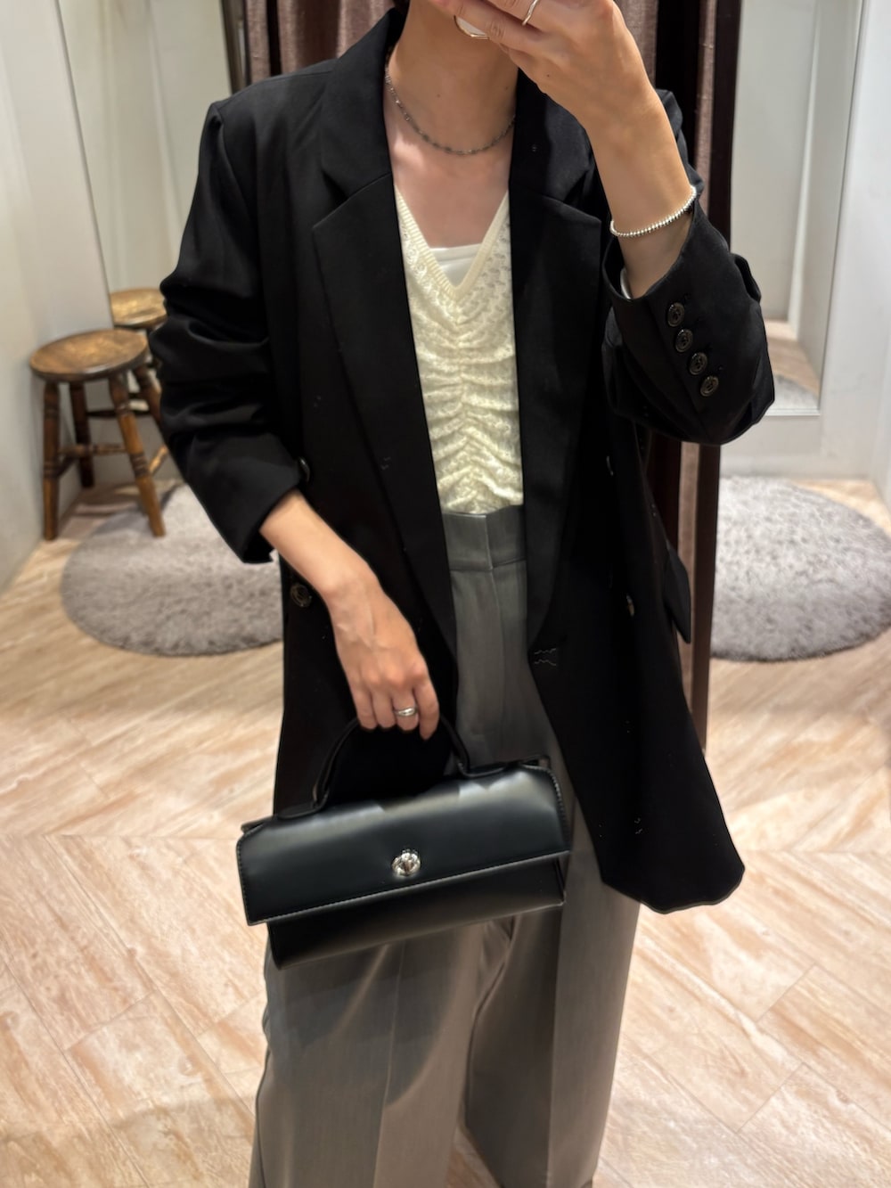 ブラック系のテーラードジャケット、ホワイト系のニット/セーター、グレー系のその他パンツを着用したレディースの秋コーディネートの2枚目の写真